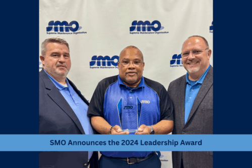 award winner holding plaque with leaders of smo