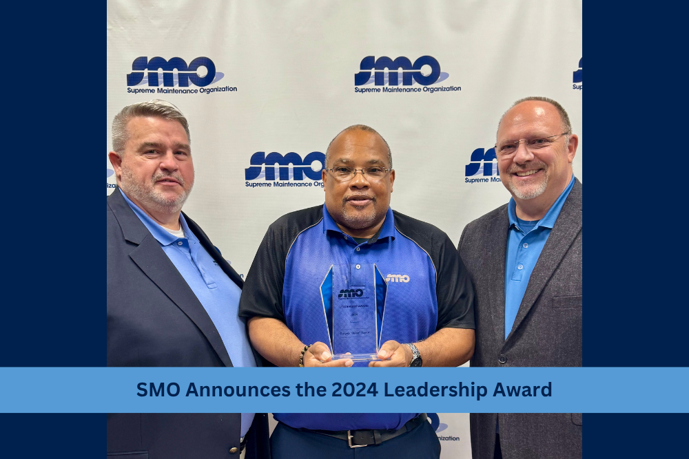 award winner holding plaque with leaders of smo