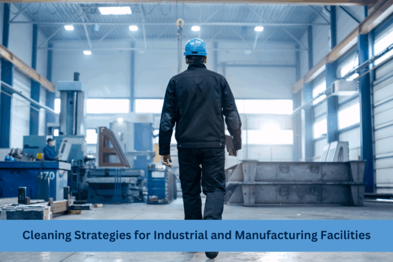 A worker in a blue hard hat and black jacket walking through an industrial and manufacturing facility with various machinery and equipment. The text 'Cleaning Strategies for Industrial and Manufacturing Facilities' is displayed at the bottom of the image.